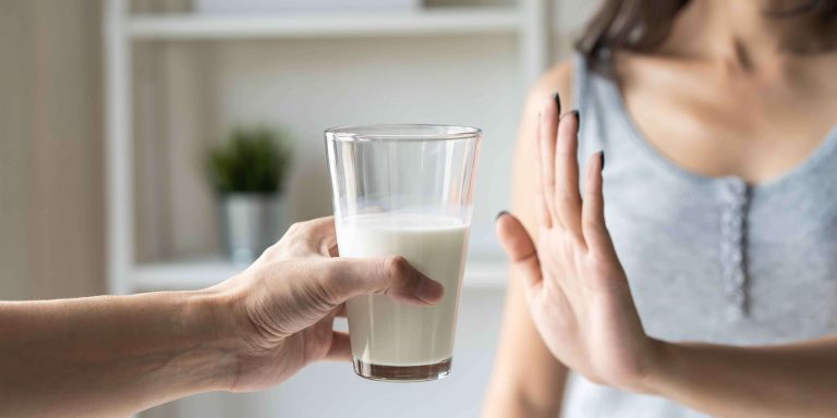 Frau hat Laktoseintoleranz und lehnt Milchglas ab